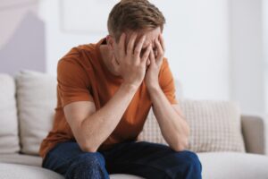 Man covering his face after wondering how long does heroin stay in the body system.